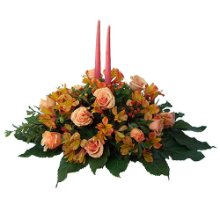 Composizione centrotavola con fiori di stagione e candele.